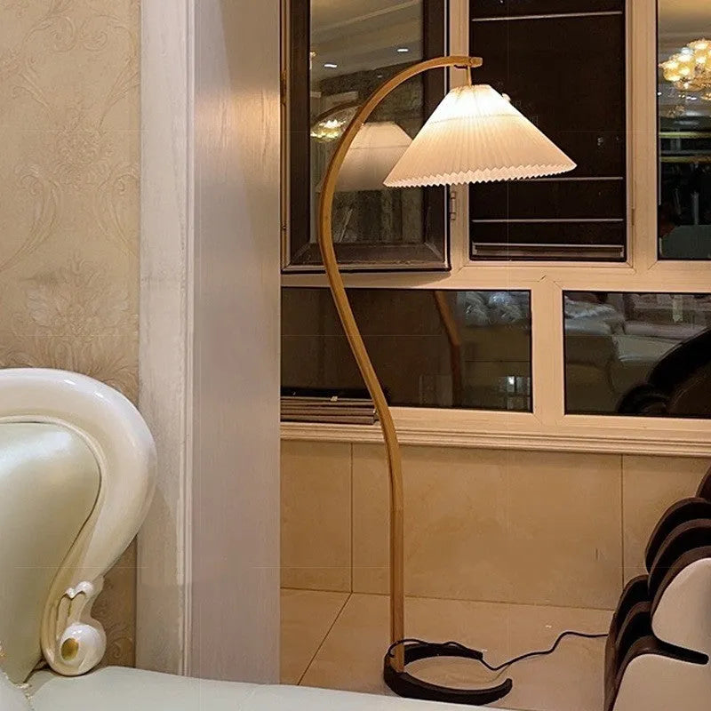 Retro-style vertical table lamp with log white lampshade placed on a sofa arm.