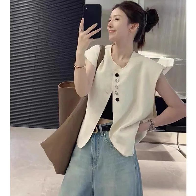 Women's solid colour polyester vest with pockets in loose fit and short 40cm length.