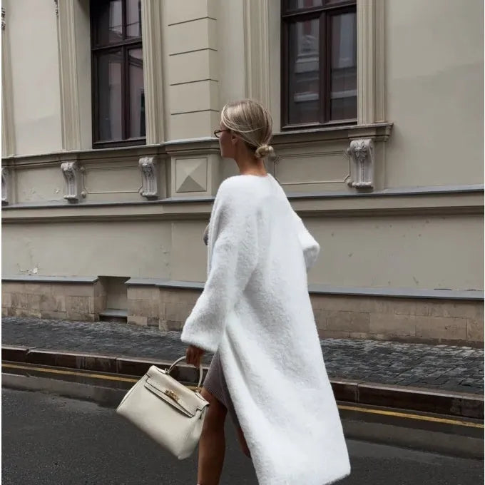 White longline knitted cardigan jacket with long sleeves on a hanger.