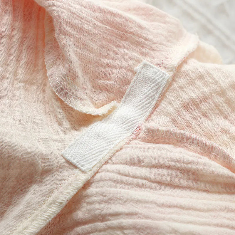 Women's pink pure cotton gauze long sleeve lounge suit with matching trousers on a hanger.