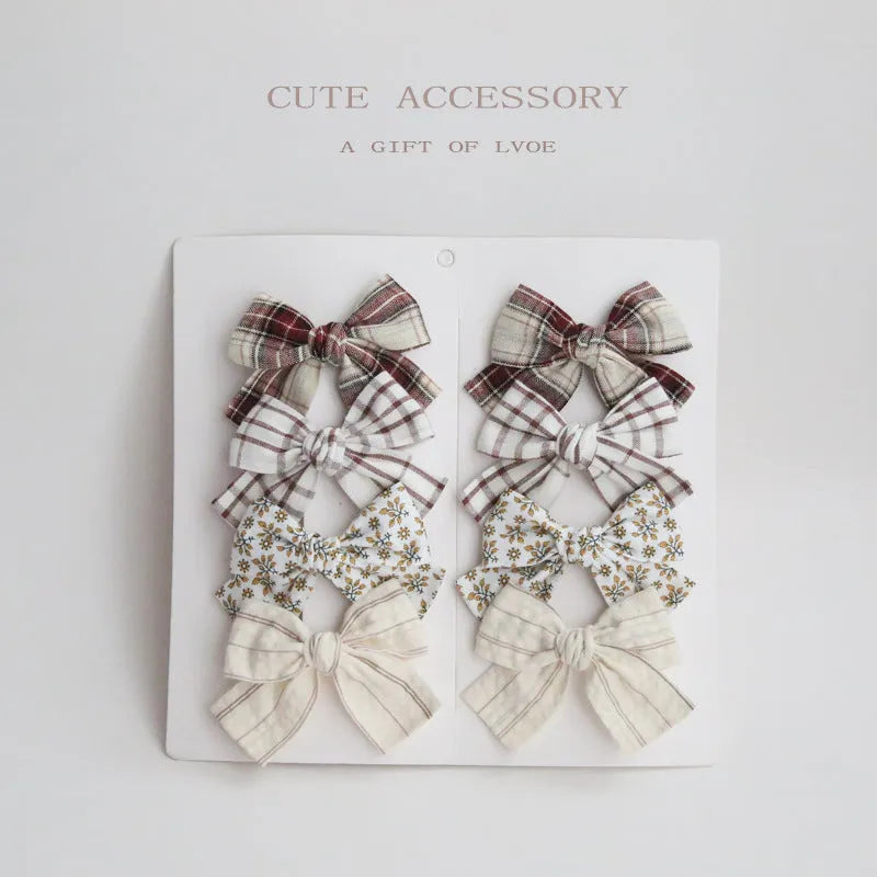 Set of children's cloth hair clips with a dovetail bow design in various colours.
