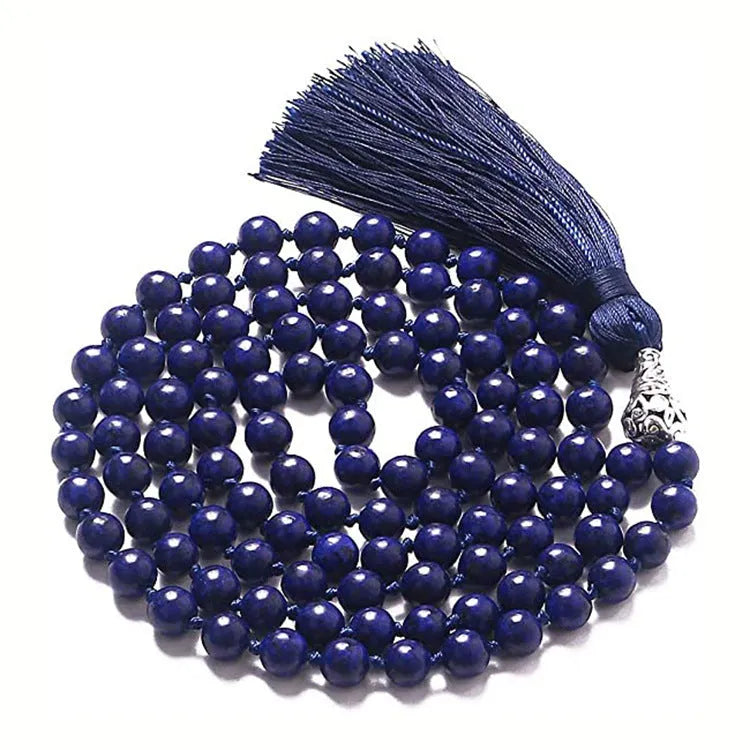 Long blue patterned agate and stone tassel necklace with geometric beads on a white background.