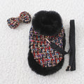 Dog wearing a beret-style cloak attached to a cloth chest strap harness with a hand-held rope.