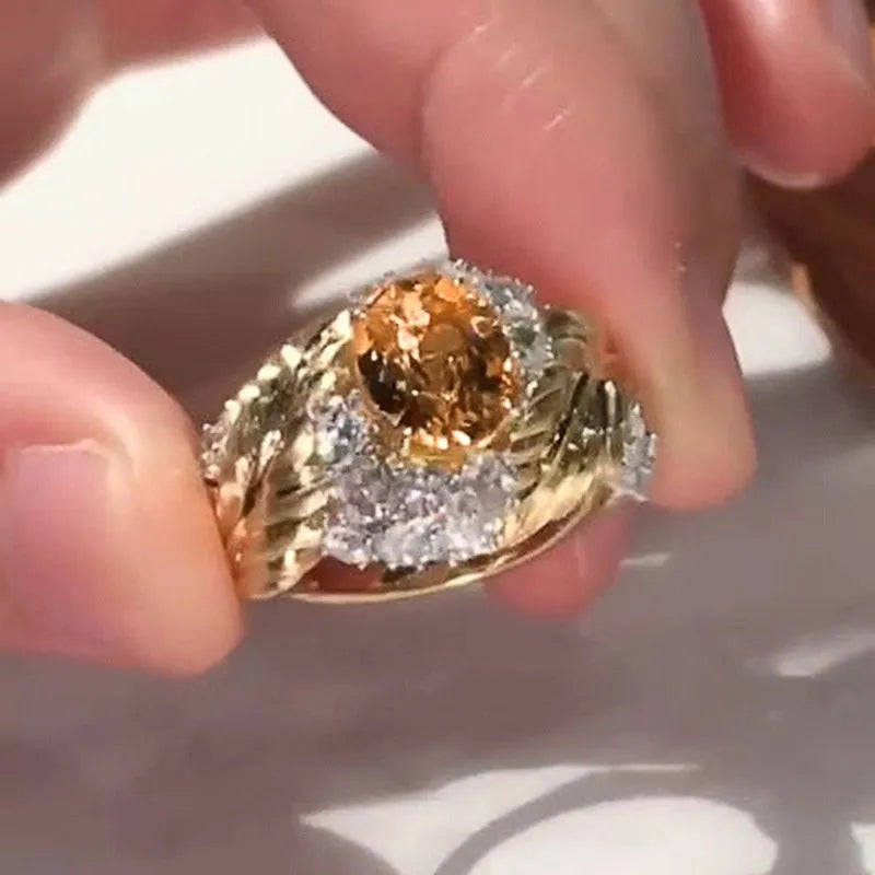 Gold-coloured women's ring with embossed feather pattern and yellow zircon gemstone