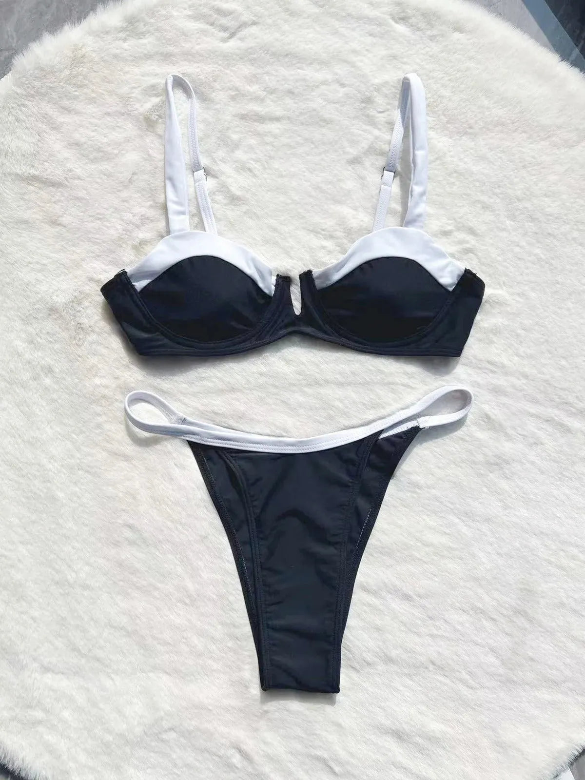 Black low waist women's bikini swimsuit with stitching split detail on a mannequin.