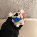 Handmade knitted koala bear backpack cover for AirPods charging case on a table.