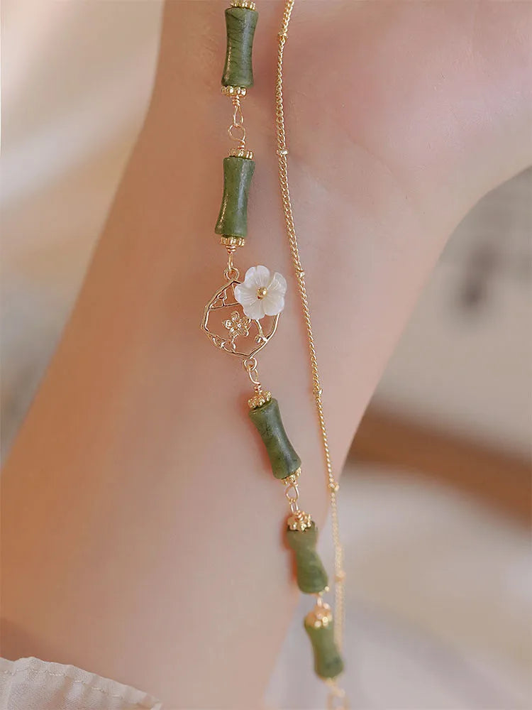 Handmade double layer olivine bracelet with Bells of Ireland charms on a model's wrist