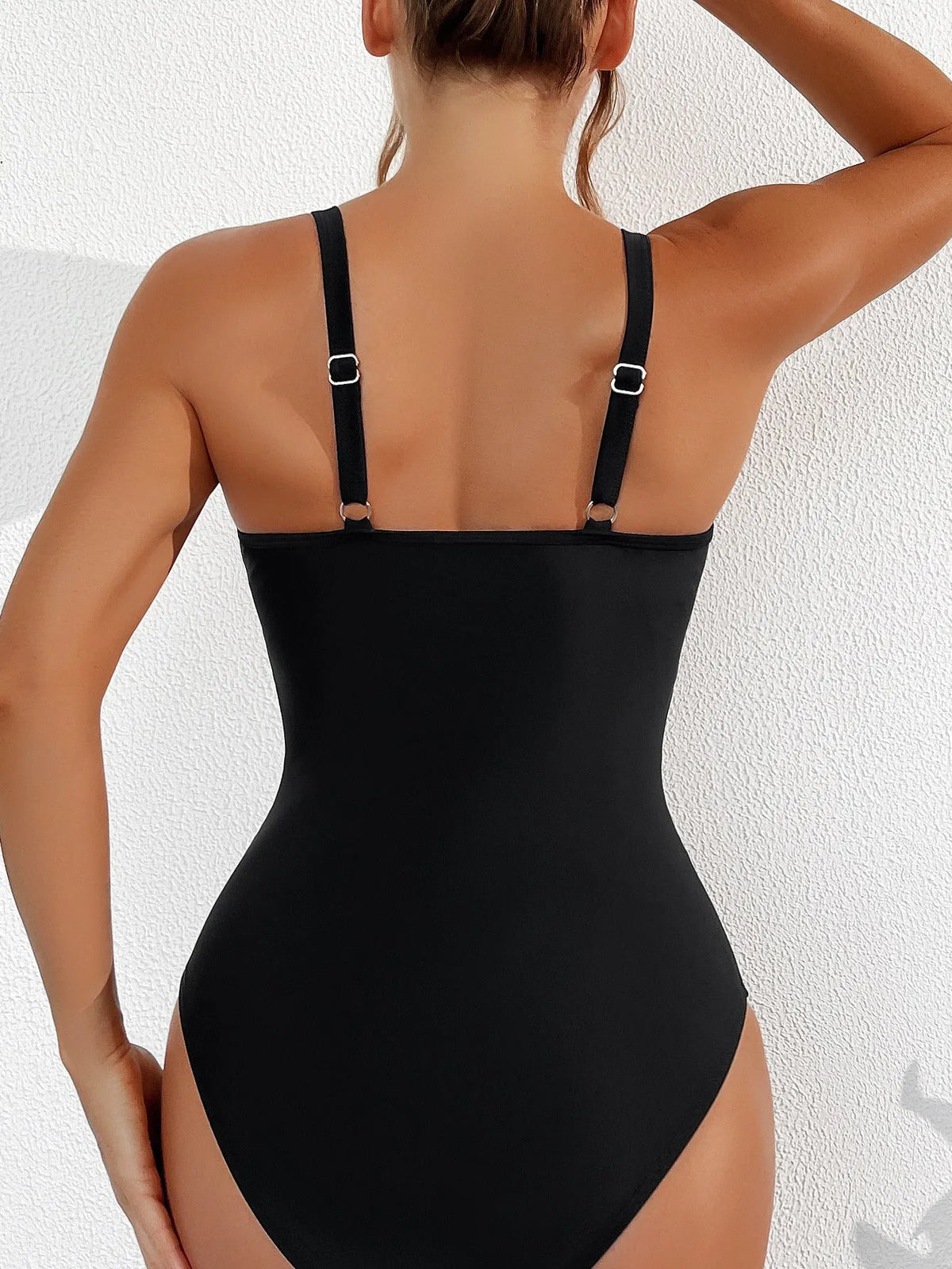 Black women's one-piece halter swimsuit with mesh detailing and attached briefs, shown on a size chart.
