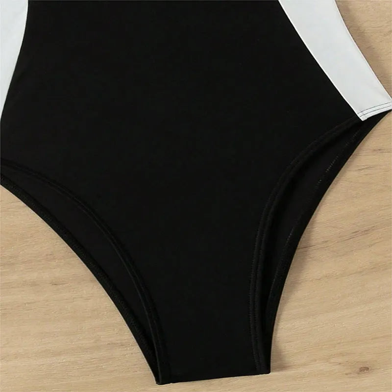 Black and white women's one-piece swimsuit with spaghetti straps and slimming cut