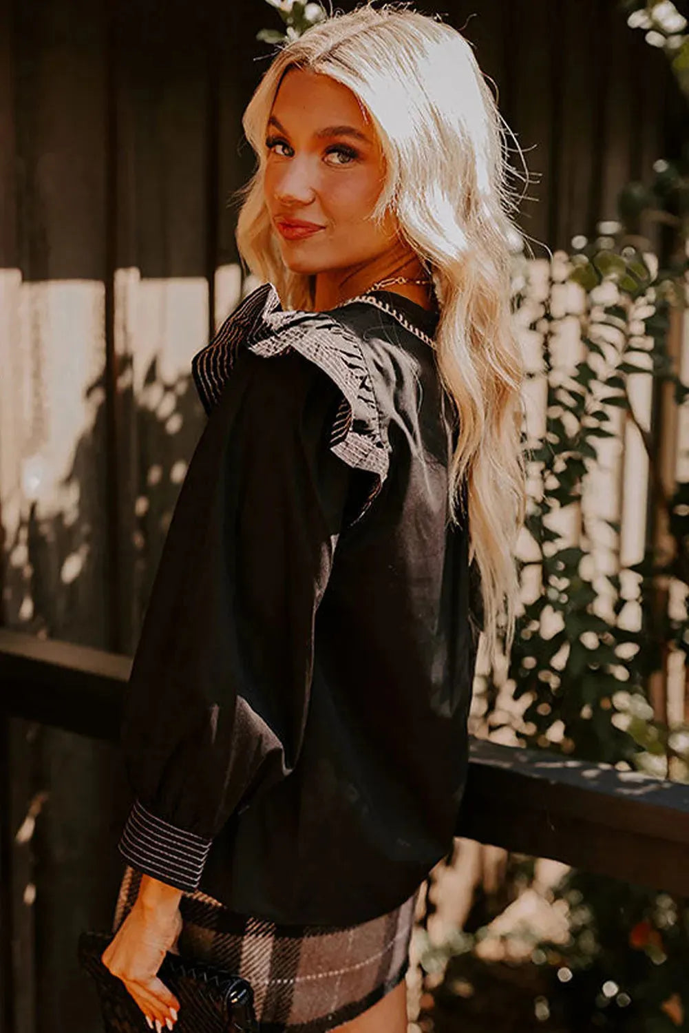 Black women's blouse with V-neckline and long ruffle sleeves