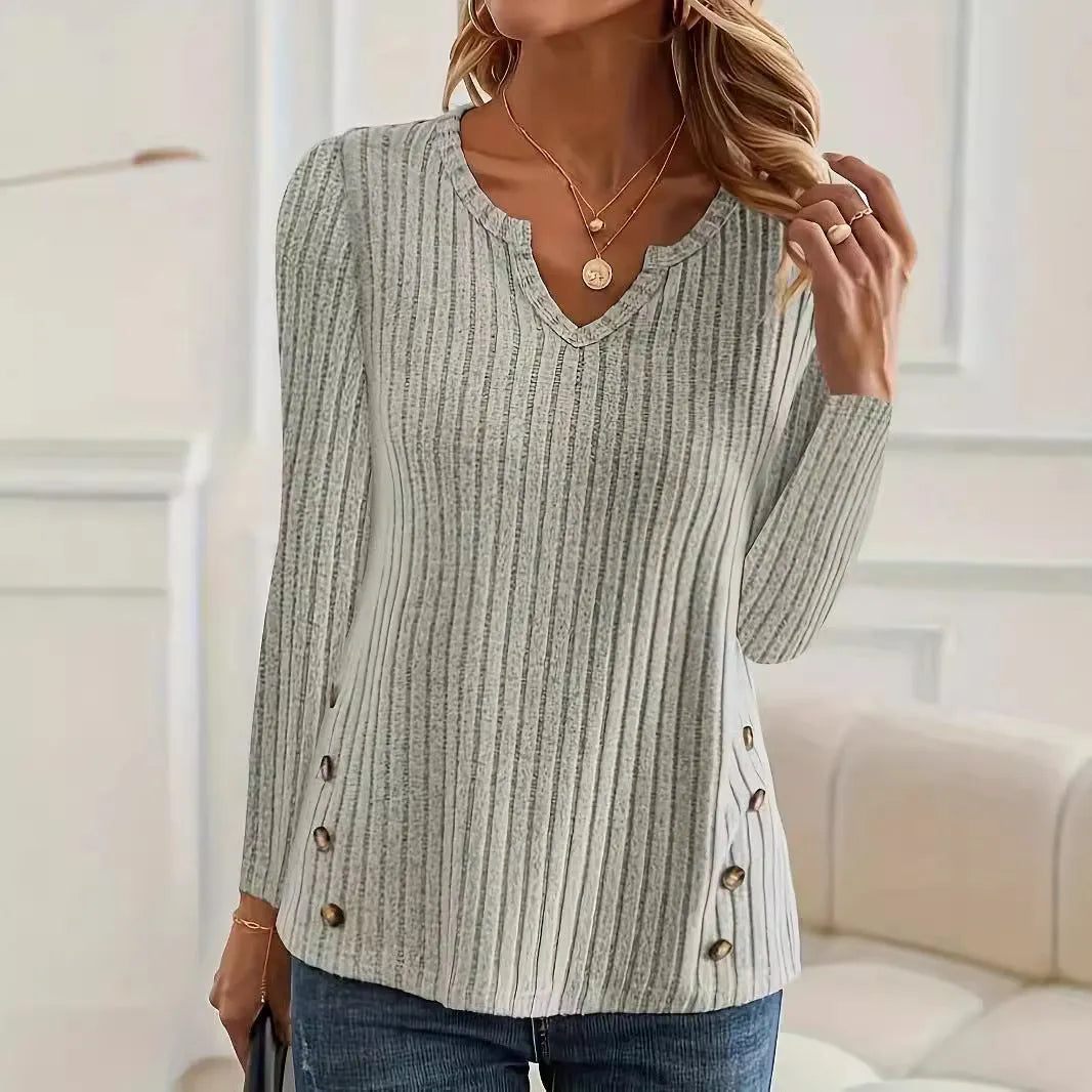 Man wearing a solid grey green knitted pullover sweater with a button detail on the chest.