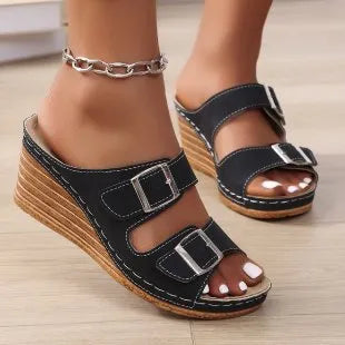Women's creamy-white beach slippers with a wedge heel and an adjustable buckle strap across the foot.
