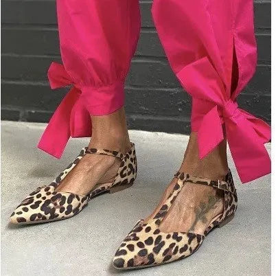 Women's leopard print pumps with a pointed toe, low chunky heel, and a cross shoulder strap.