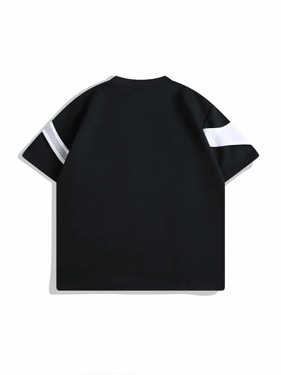 Man wearing a black loose fit short sleeve t-shirt with double stitching and padded shoulders.