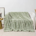 Thick coral fleece flannel sofa blanket in a solid colour, laid flat showing its texture.