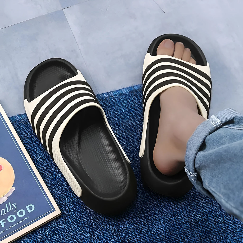 A pair of casual unisex slippers with a PVC upper and EVA sole, shown in one of four available colour options.