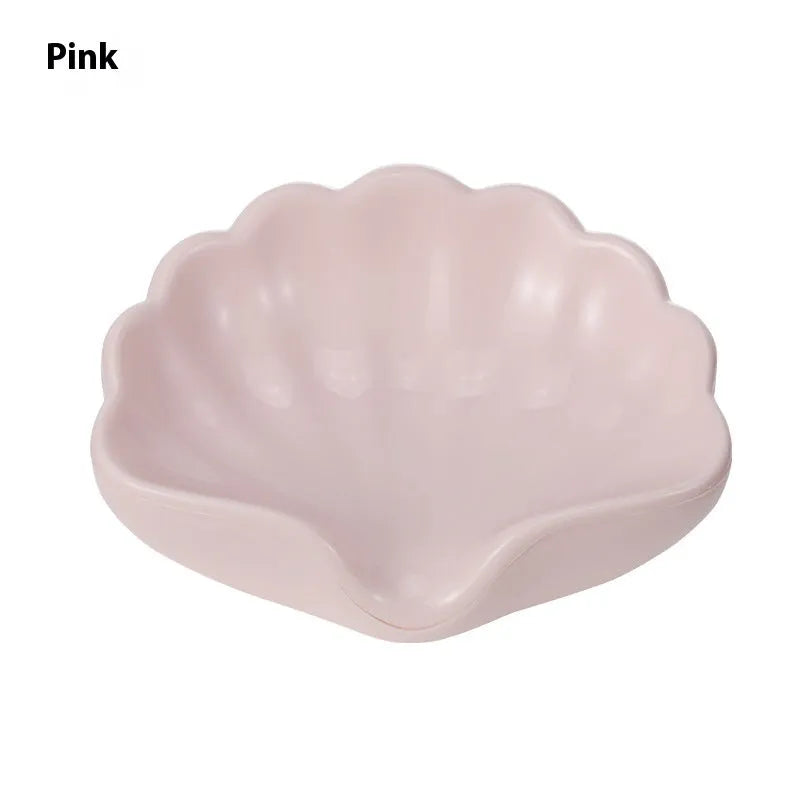 White plastic shell-shaped soap dish for bathroom countertop or wall.