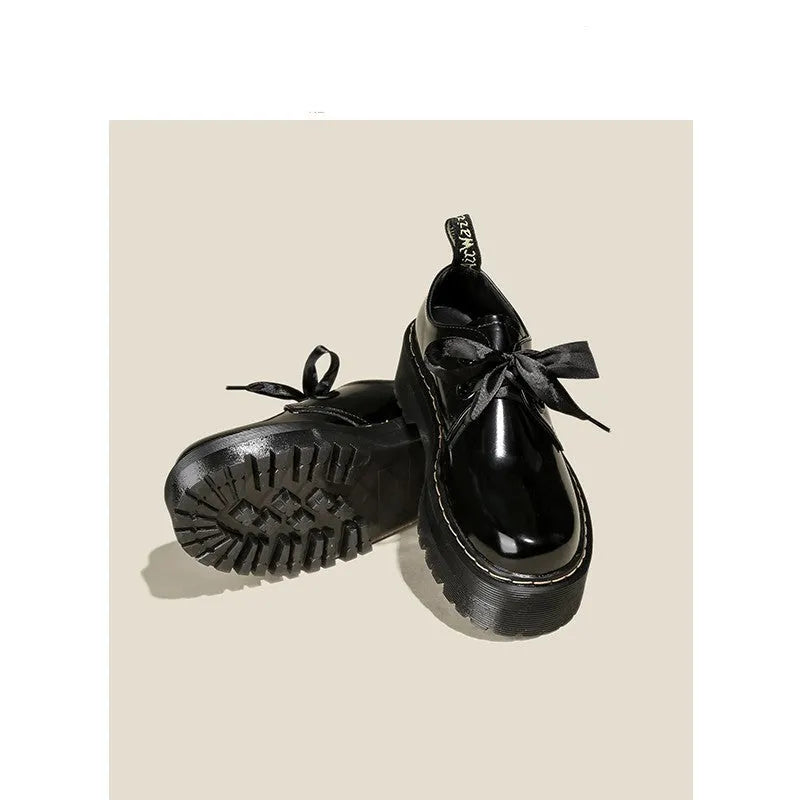 Women's black leather shoes with thick sole, cross strap, and ribbon lacing closure