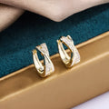 A pair of geometric drop earrings in 14K yellow gold colour, made from copper with a zircon treatment detail.