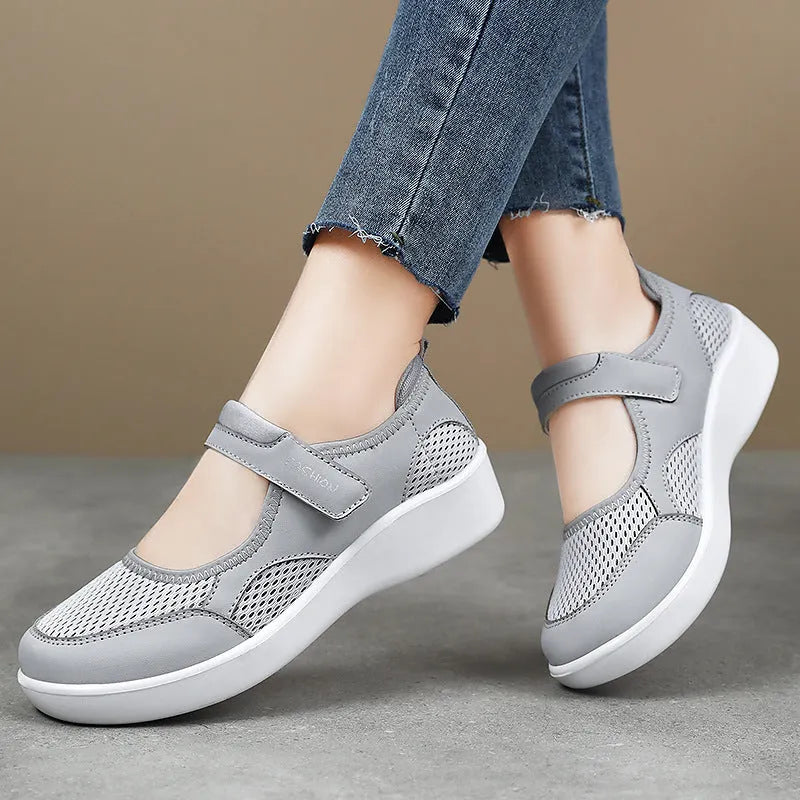 Women's low-top casual sneaker in grey mesh with velcro strap and flat polyurethane sole.