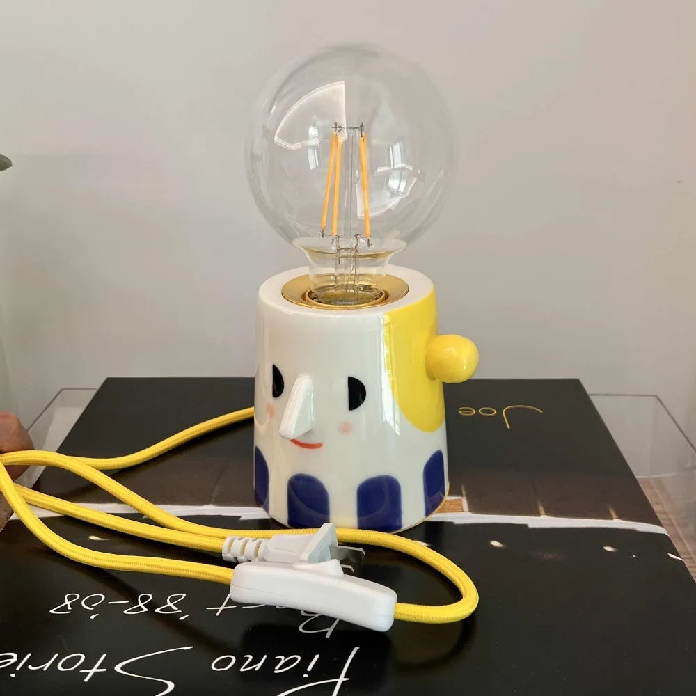 Handmade ceramic table lamp with ball-shaped shade on wooden surface
