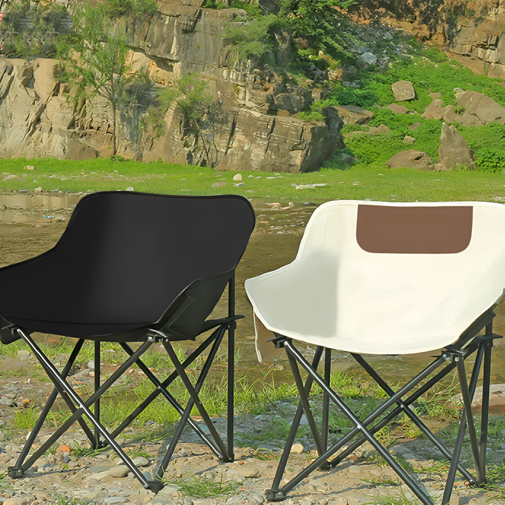 Beige folding camping chair with reclined back and steel frame on grass.