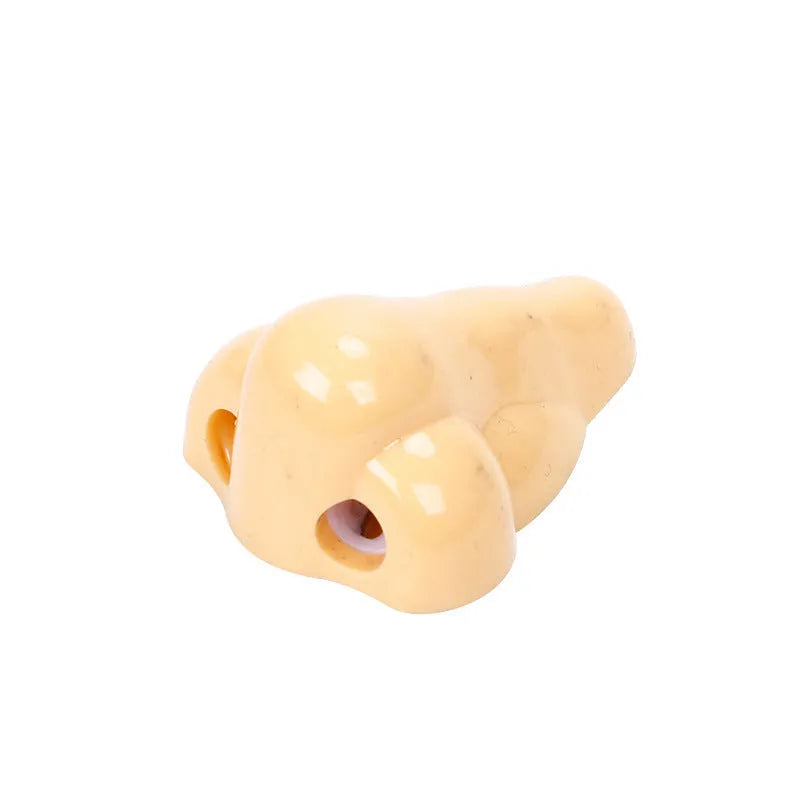 Flesh coloured plastic manual pencil sharpener with a geometry shape and large nostril opening.