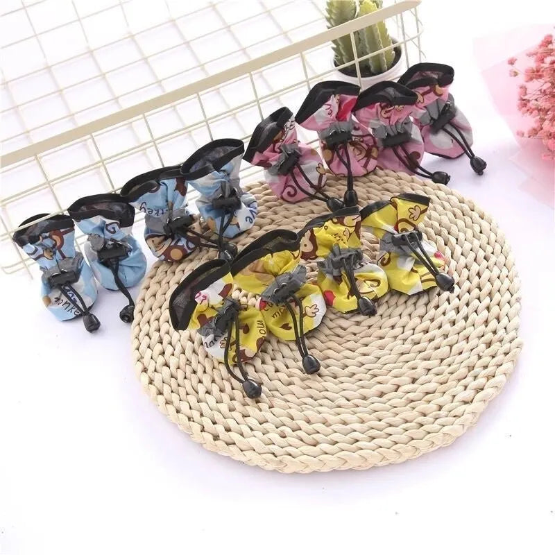 Set of four cloth dog shoes in various colours including fleece-lined red and monkey patterns