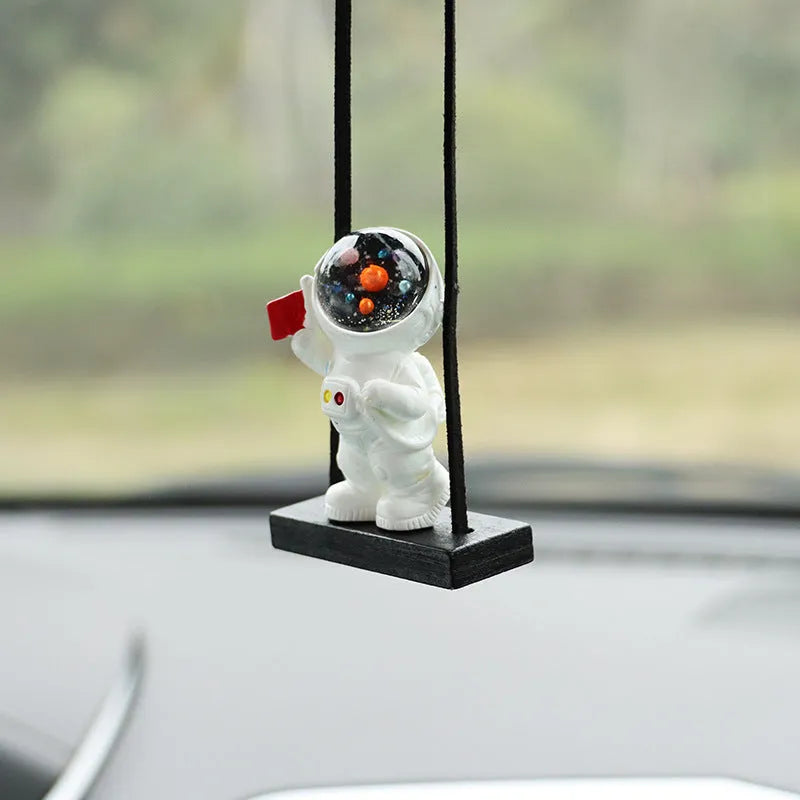 Resin astronaut car pendant showing five colour options including telescope and red flag designs