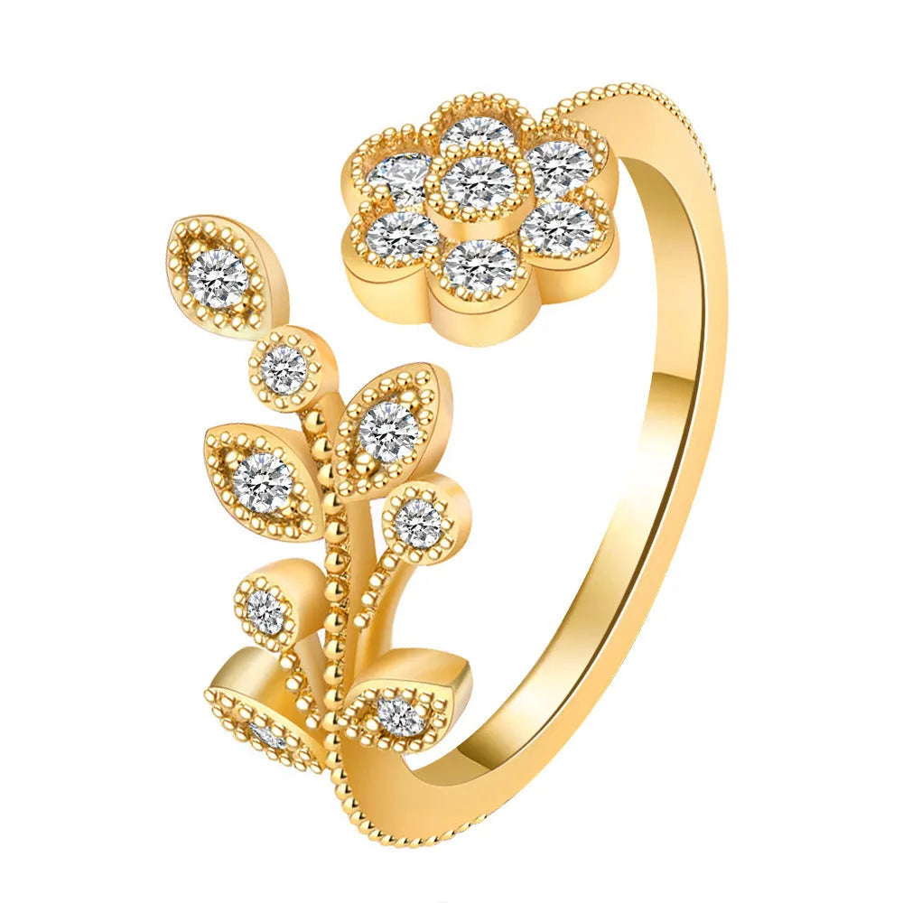 Close-up of a women's open ring with detailed floral leaf engraving, shown in gold colour finish.
