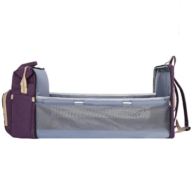 Folding mummy crib bag with curved shoulder strap showing USB interface and expandable storage design