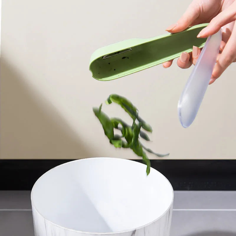 Dark green fruit vegetable peeler with storage tube showing stainless steel blade and hanging hole