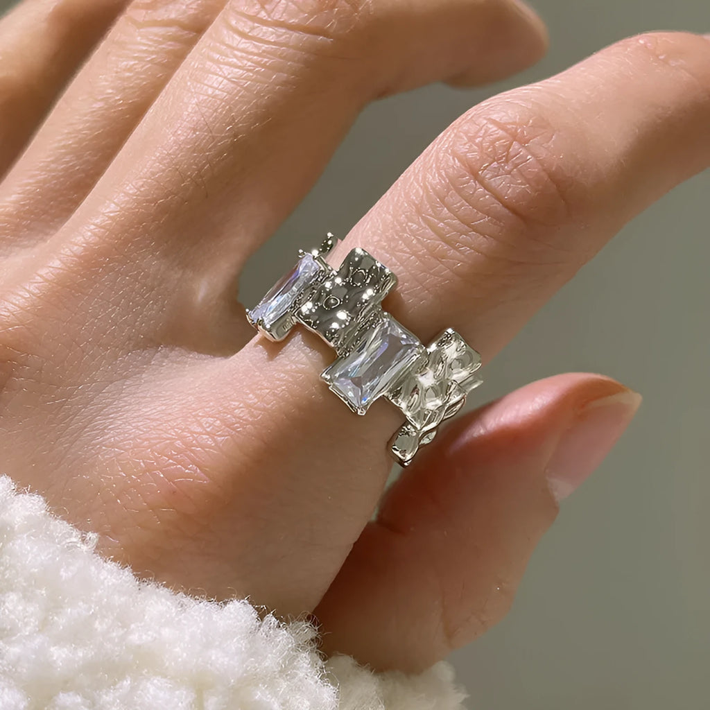 Silver geometric cross ring with open gemstone setting and three-dimensional decoration