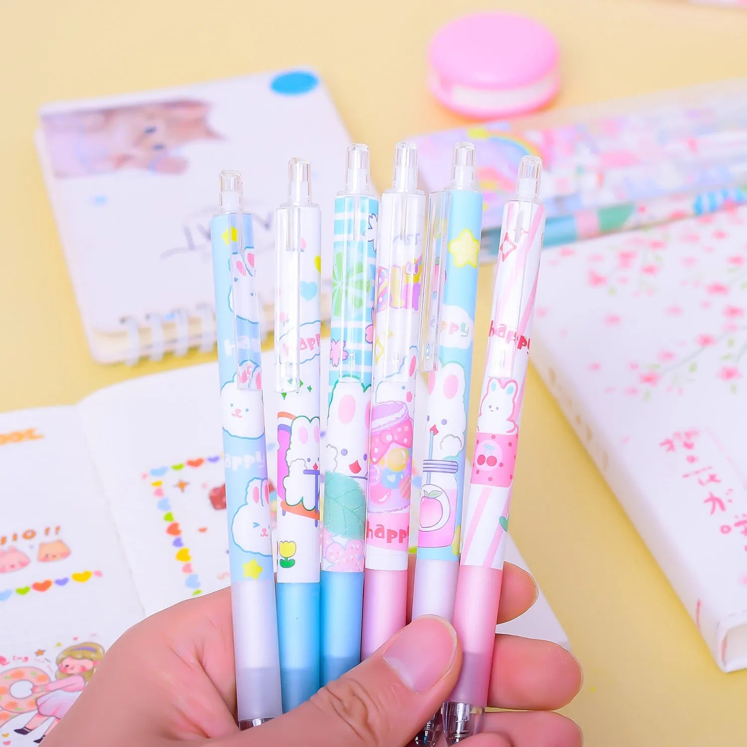 Six black plastic pens with cartoon bunny designs and 0.5mm tips arranged in stationery set