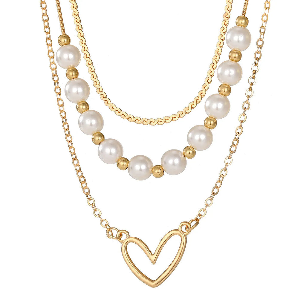 Vintage gold necklace with love heart pendant on a pearl chain, adjustable length.