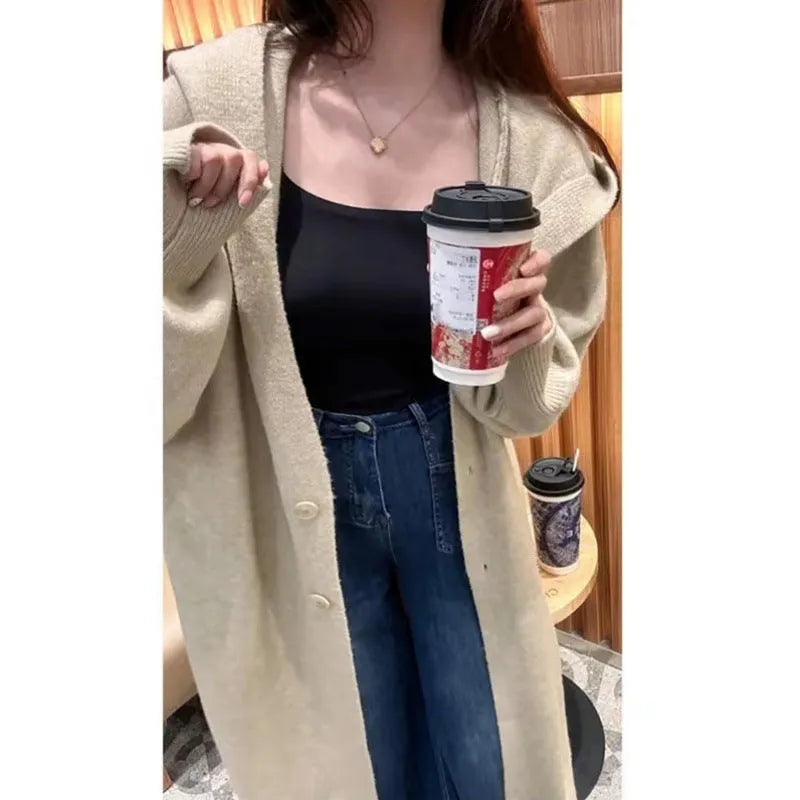 Women's long brown knitted hooded cardigan with a loose fit and below-the-knee length.