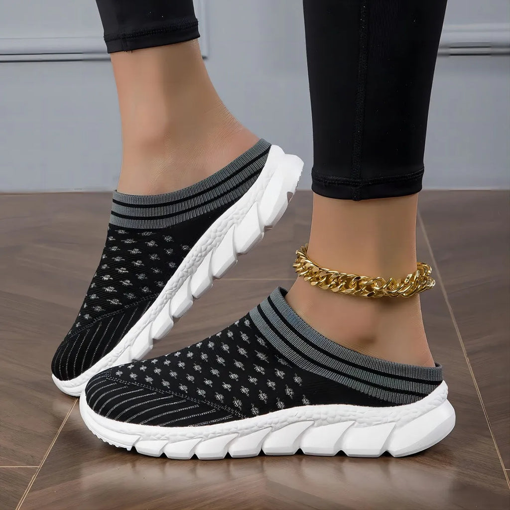 Women's black flyknit slippers with hollowed-out pattern and a height-increasing viscose sole.