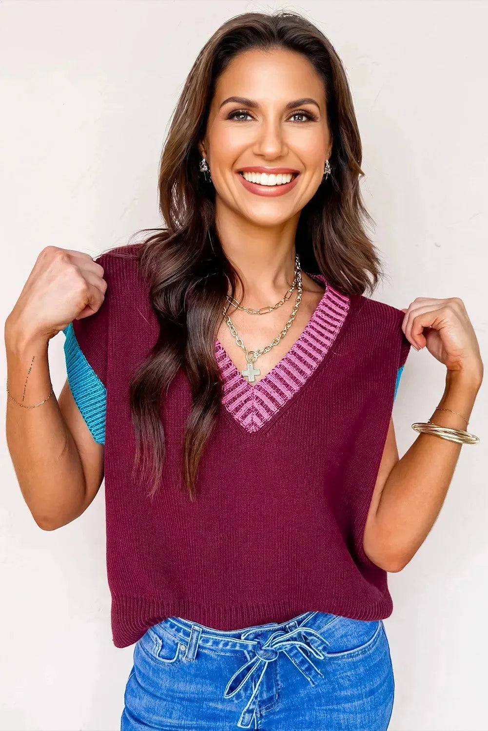 Burgundy and black loose V-neck sweater with cuffed short sleeves on a neutral background