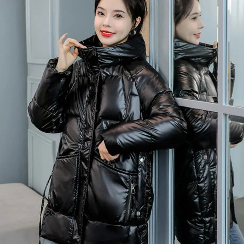 Women's green thick loose fit hooded winter jacket with long sleeves on a hanger.