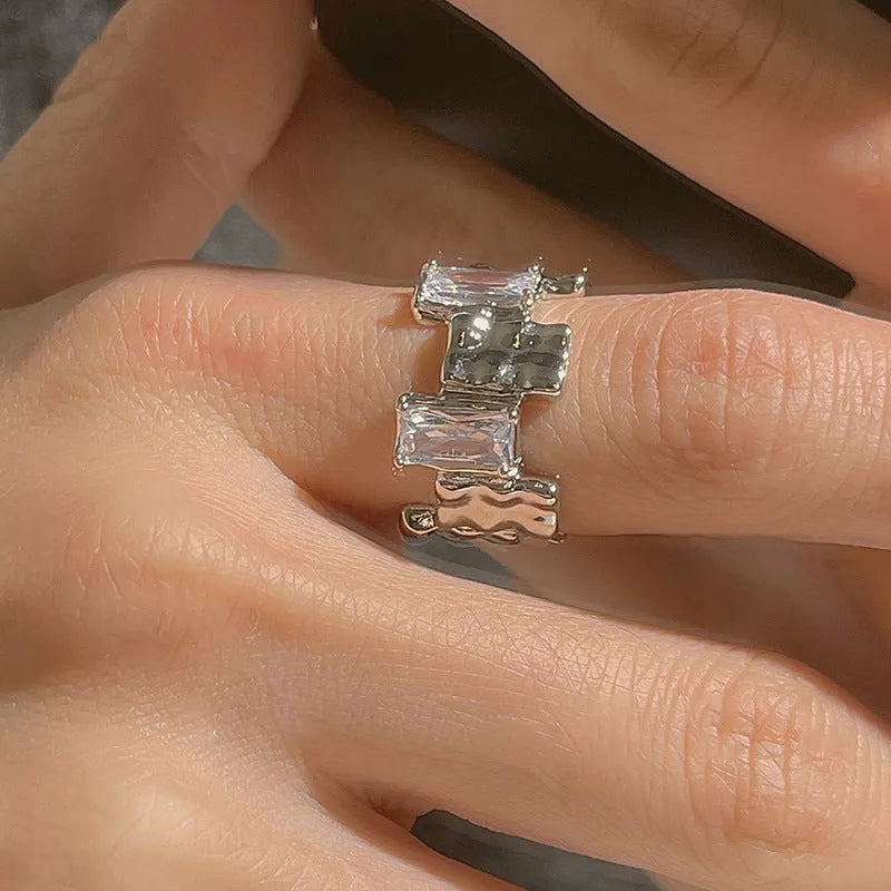 Silver geometric cross ring with open gemstone setting and three-dimensional decoration