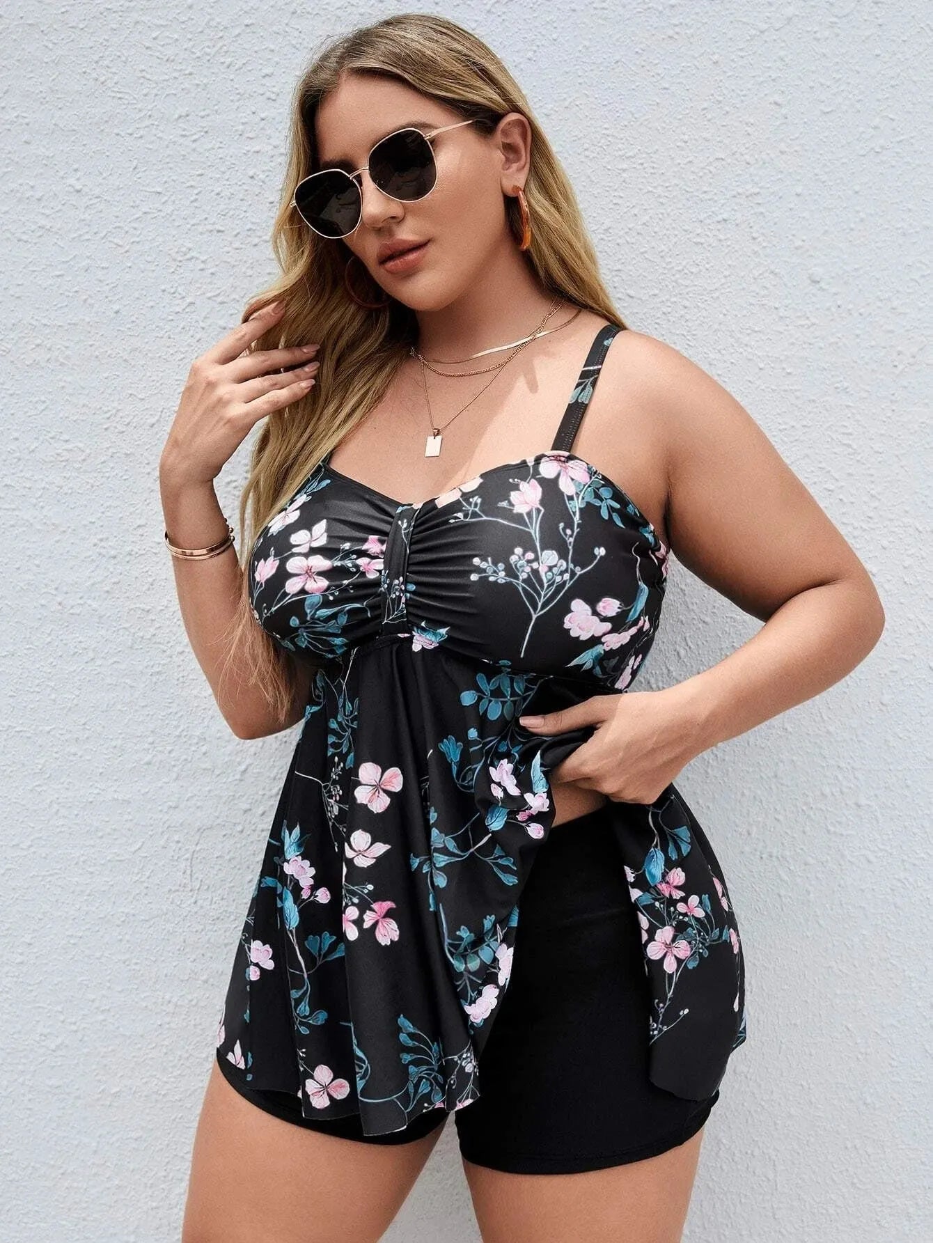 Women's floral print one-piece swimsuit on a hanger, showing split colour design