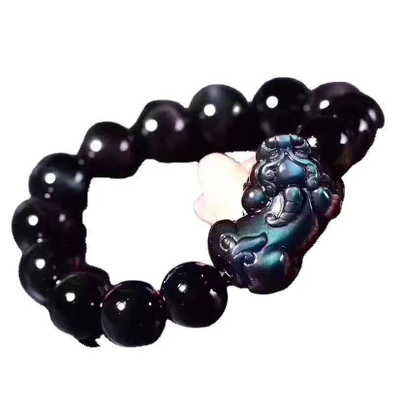 Natural ice colour eye obsidian crystal bracelet on a wrist, showing polished beads on an elasticated band.