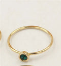 Women's copper knuckle ring with gilded finish and zircon stones in green, blue, red, and white.