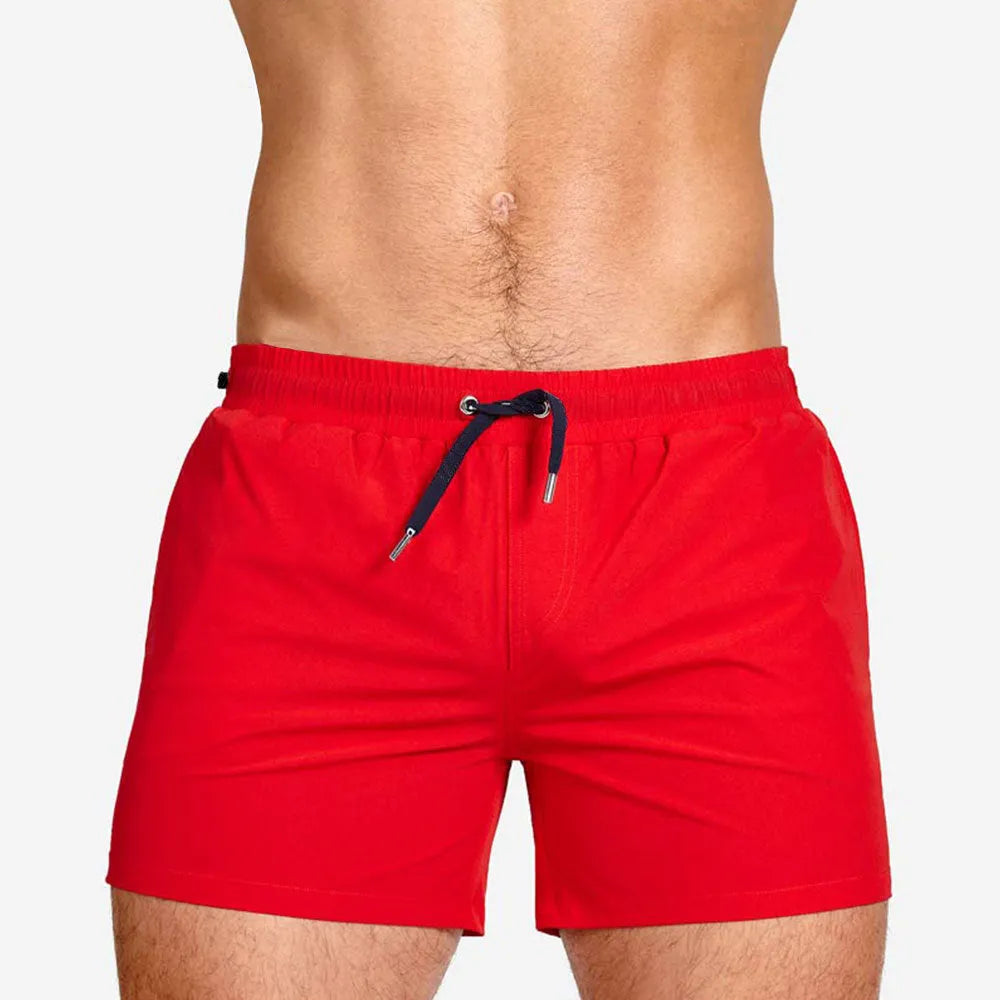 Men's solid colour polyester swimming shorts with mesh lining for sports and fitness.