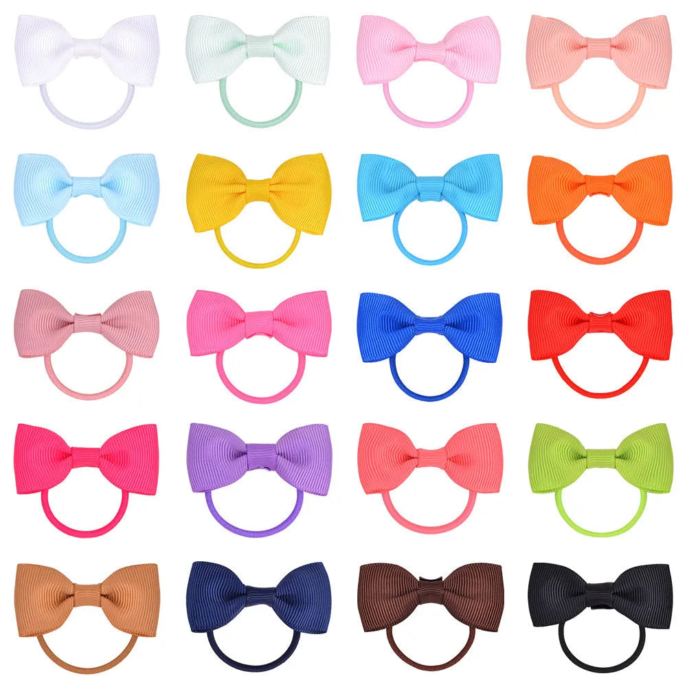Multi-coloured baby hair ties with small grosgrain ribbon bows, soft elastic bands for infants and toddlers.