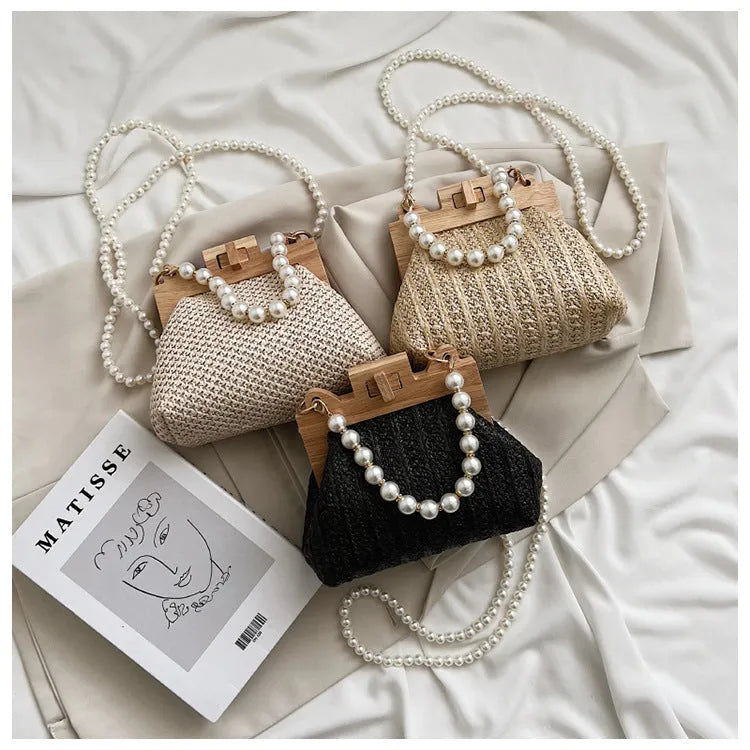 Women's straw woven shoulder bag with pearl chain trim showing internal compartments