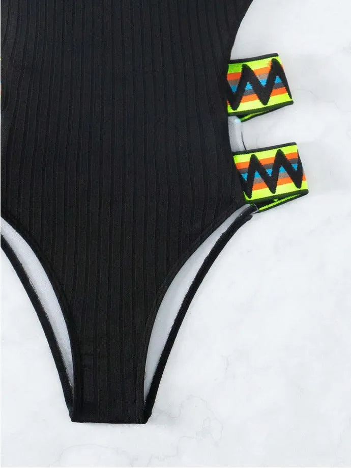 Solid colour women's one-piece swimsuit on a hanger, available in black and orange.