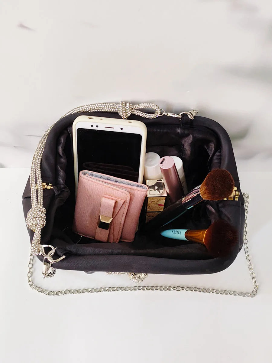 Women's soft polyester messenger bag with diamond folds and chain detailing in black colour