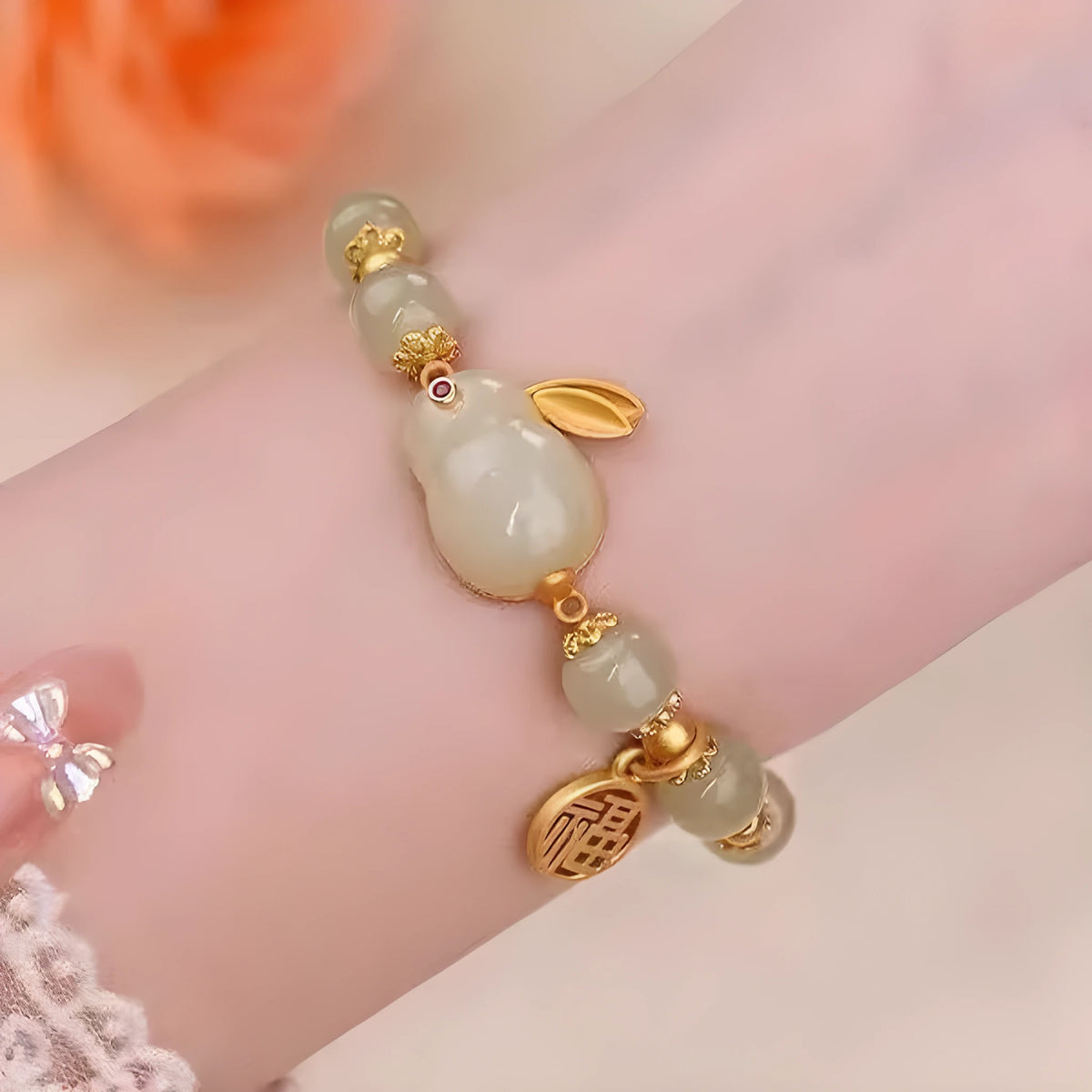 Women's green jade bracelet with black hand charm and hare pendant featuring fu character and lily motifs