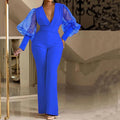 Red women's long sleeve jumpsuit with mesh stitching detail on sleeves and wide leg trousers.